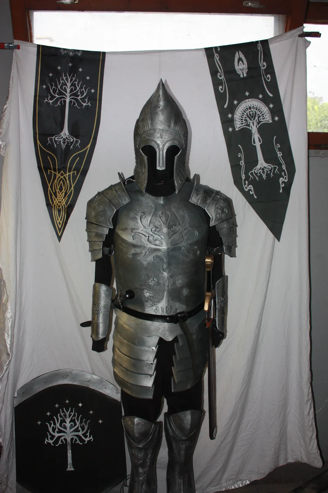 Full Gondorian armor in front of White Tree banners