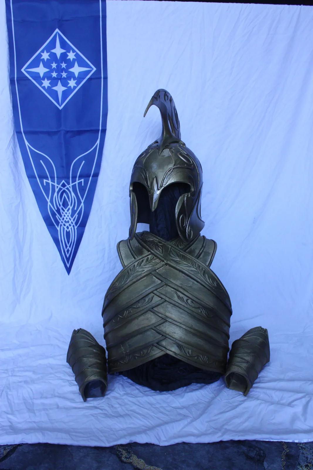 Elven armor and helmet in front of a blue banner with stars